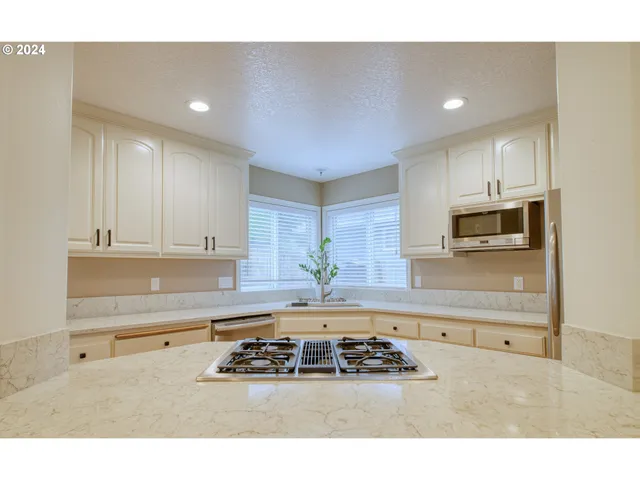 a kitchen with kitchen island sink stove and cabinets
