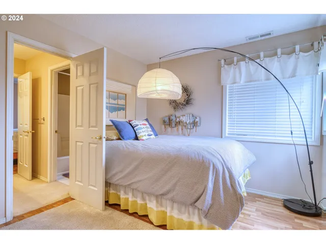 a spacious bedroom with a bed and a dresser