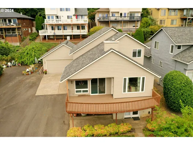a view of a white house with large windows and a yard