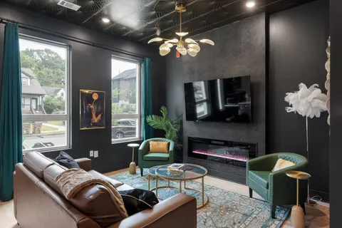 a living room with furniture a chandelier and a fireplace