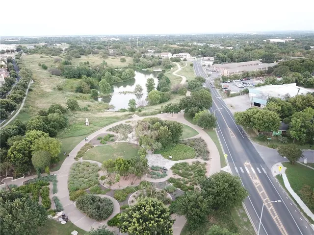 an aerial view of residential houses with outdoor space and trees