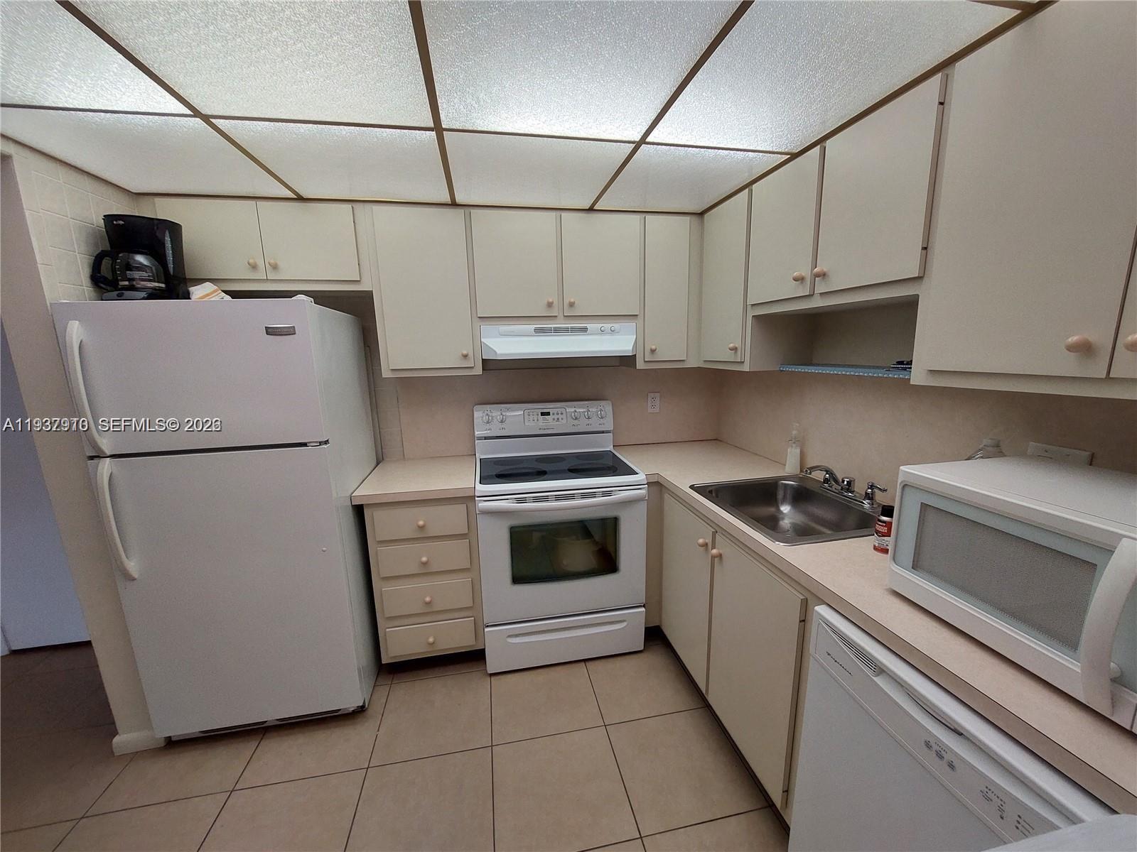 253 South Cypress Road, Unit 206 Pompano Beach, FL 33060 - Photo 9 of 30 a kitchen with cabinets appliances and a sink