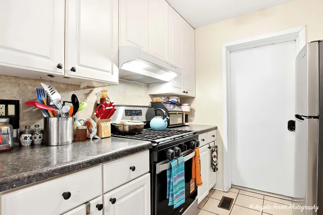 a kitchen with stainless steel appliances granite countertop a sink and a white cabinets