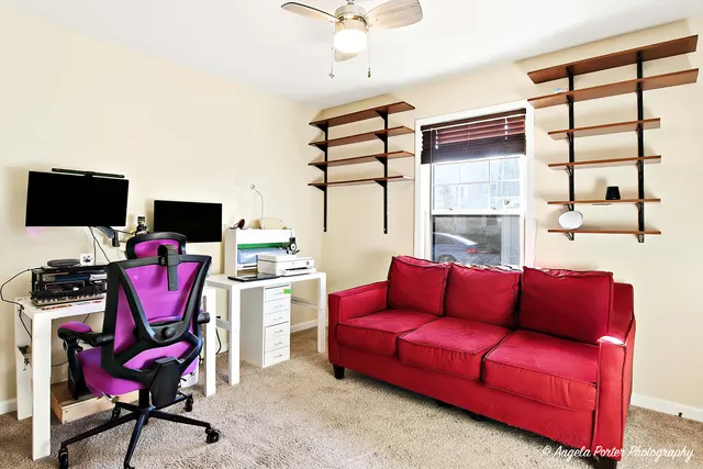a living room with furniture a flat screen tv and white walls