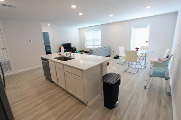 a kitchen with a sink and wooden floor