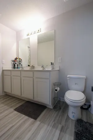 a bathroom with a toilet sink and mirror