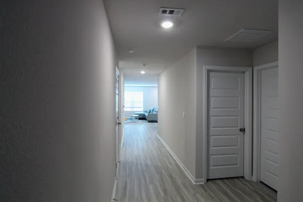 a view of a hallway with wooden floor and closet