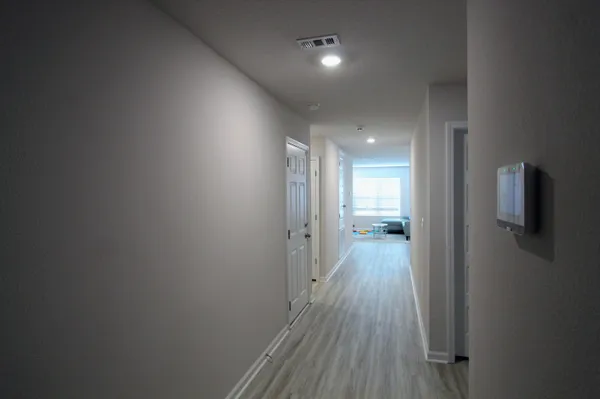 a view of a hallway with wooden floor