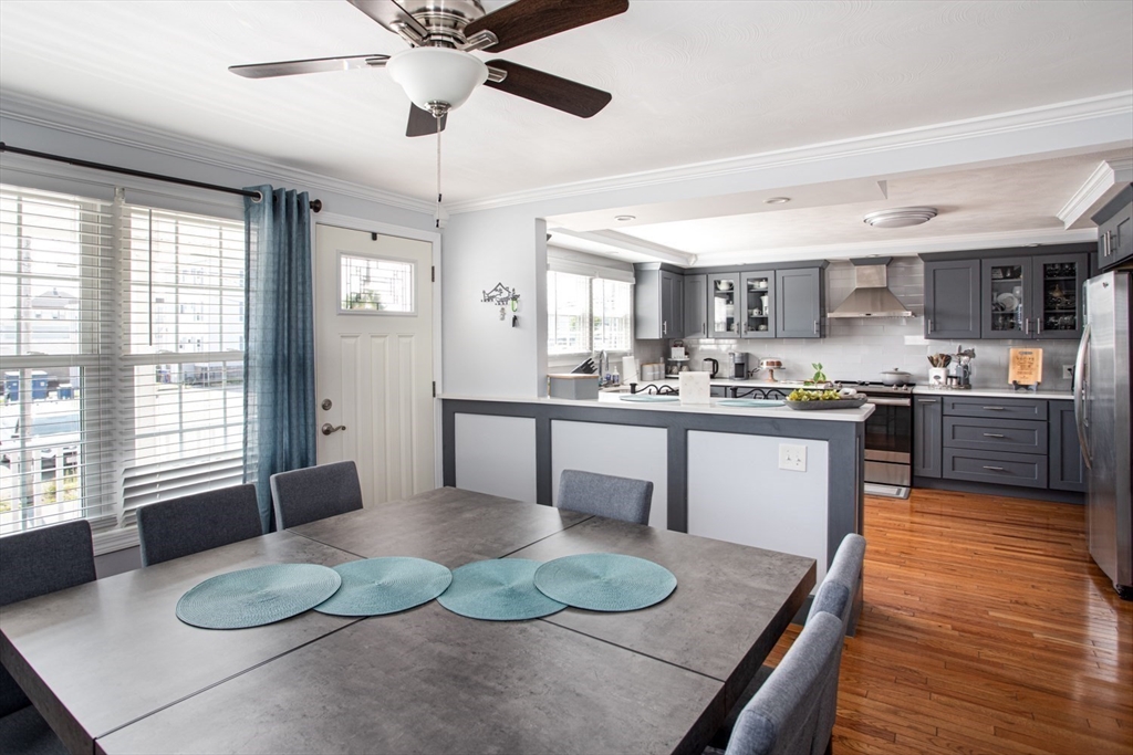 357 Baker Street Fall River, MA 02721 - Photo 4 of 31 a kitchen with a table chairs stove and wooden floor