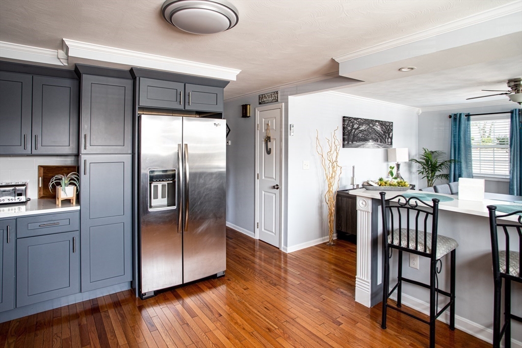 357 Baker Street Fall River, MA 02721 - Photo 6 of 31 a kitchen with stainless steel appliances granite countertop a refrigerator a stove and a dining table with wooden floor