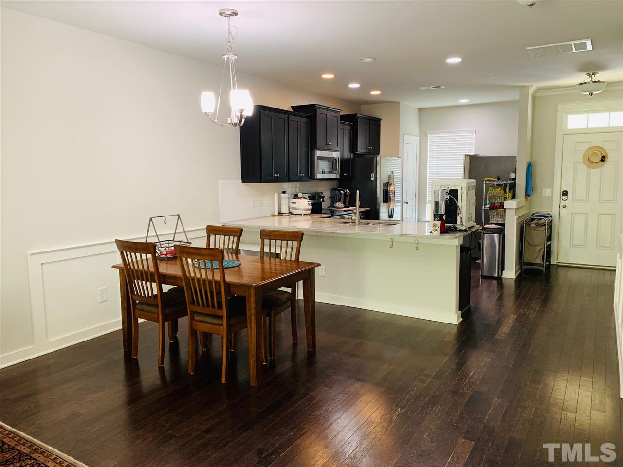 7804 Allscott Way Raleigh, NC 27612 - Photo 3 of 16 a view of a dining room with furniture wooden floor and a chandelier