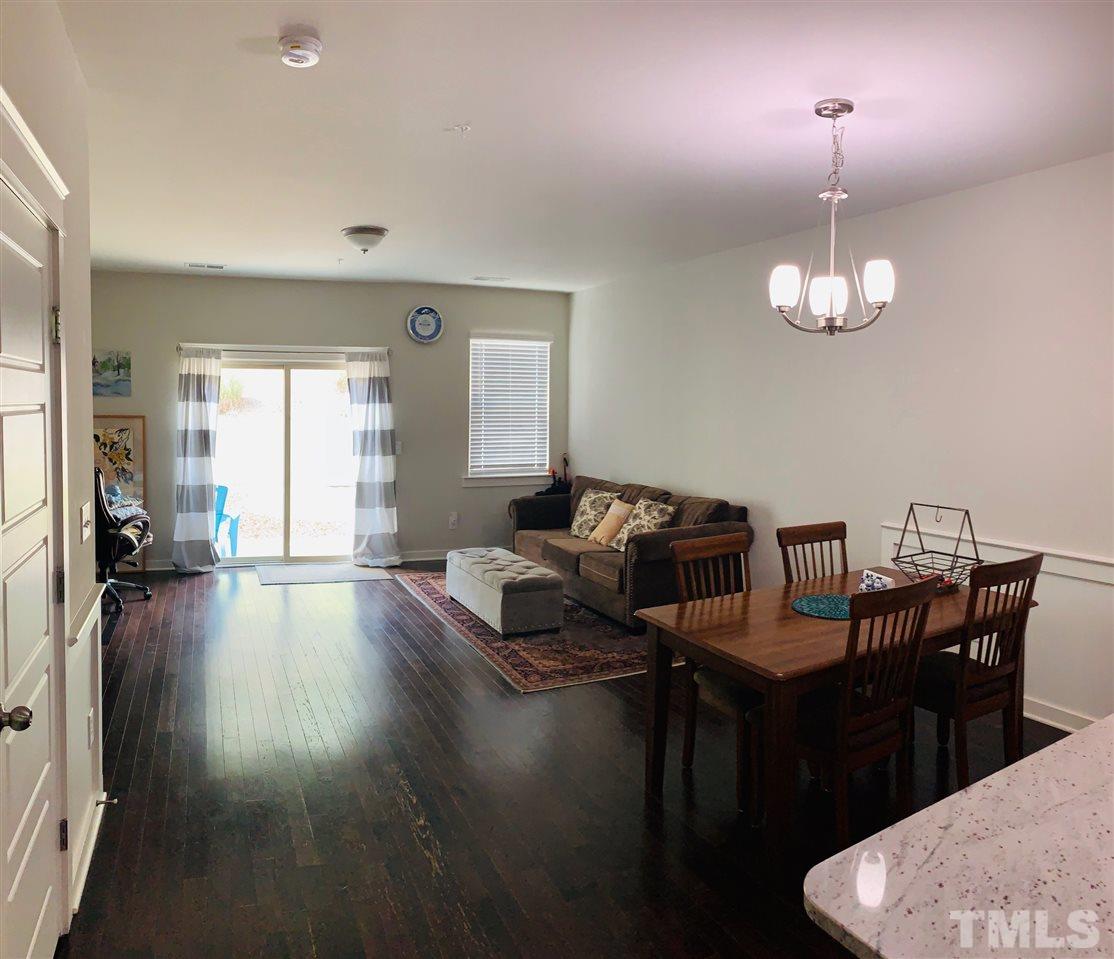 7804 Allscott Way Raleigh, NC 27612 - Photo 8 of 16 a living room with couches chairs and kitchen view with wooden floor