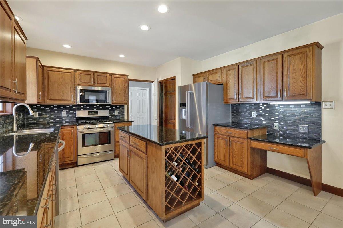 23 Laura Court Sinking Spring, PA 19608 - Photo 15 of 67 a kitchen with stainless steel appliances granite countertop a stove top oven a sink and a refrigerator