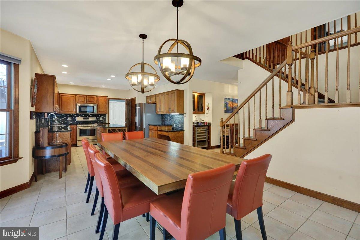 23 Laura Court Sinking Spring, PA 19608 - Photo 16 of 67 a dining room with wooden floor a chandelier a wooden table and chairs