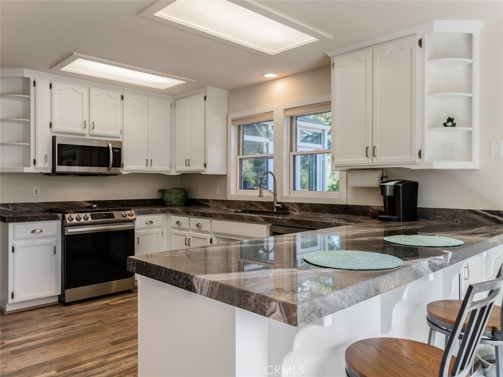 8370 Prado Lane Atascadero, CA 93422 - Photo 15 of 54 a kitchen with stainless steel appliances granite countertop a stove top oven a sink a granite counter tops and a white cabinets