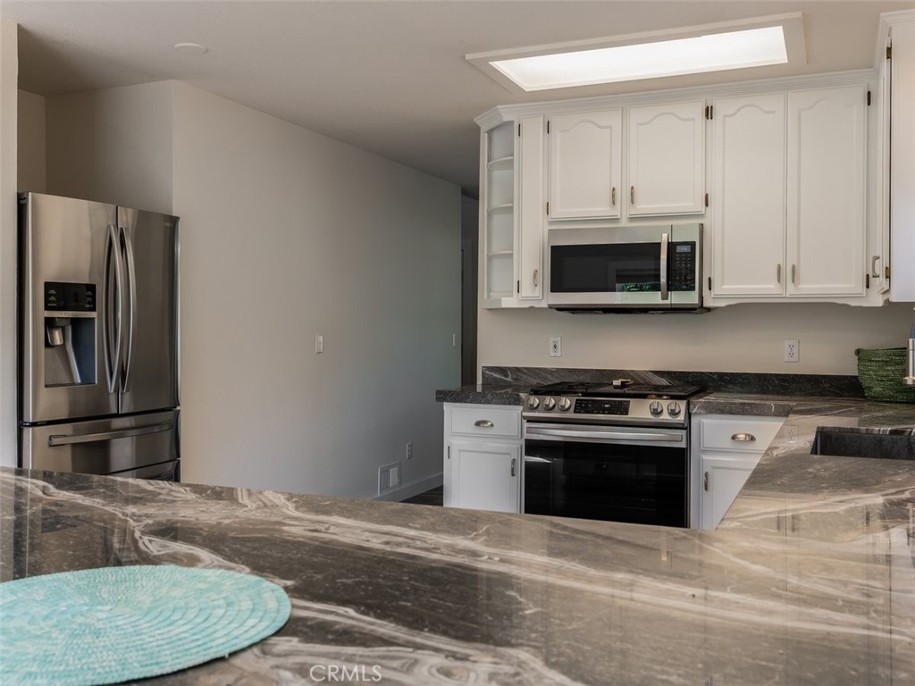 8370 Prado Lane Atascadero, CA 93422 - Photo 16 of 54 a kitchen with granite countertop a stove microwave and refrigerator