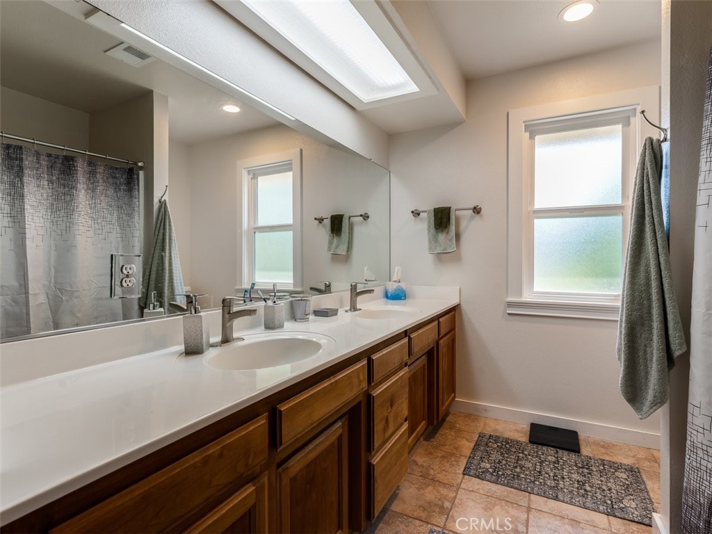 8370 Prado Lane Atascadero, CA 93422 - Photo 25 of 54 a bathroom with a double vanity sink a mirror and a bathtub