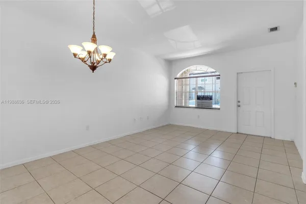 a view of a livingroom with a chandelier fan and windows