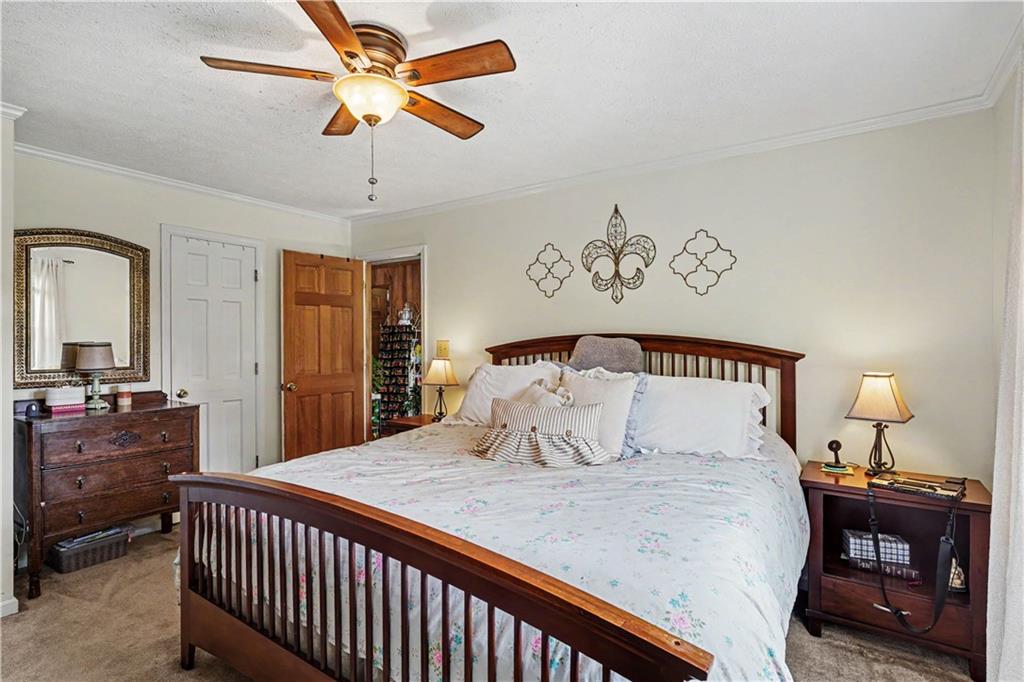 355 Inman Road Hampton, GA 30228 - Photo 23 of 47 a bedroom with a large bed and a chandelier