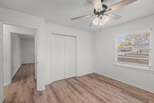 a view of empty room with window and ceiling fan