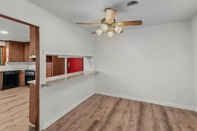 wooden floor in an empty room with a kitchen