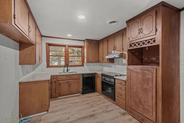 a kitchen with stainless steel appliances granite countertop a stove a sink and a microwave