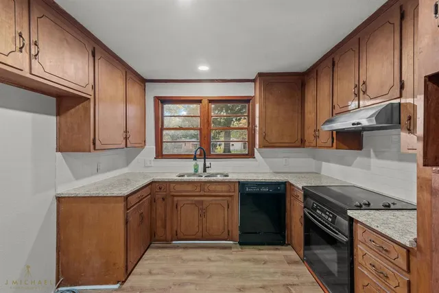 a kitchen with a sink stove top oven and cabinets