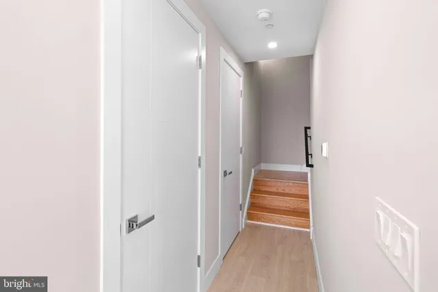 a view of a hallway with wooden floor and entryway