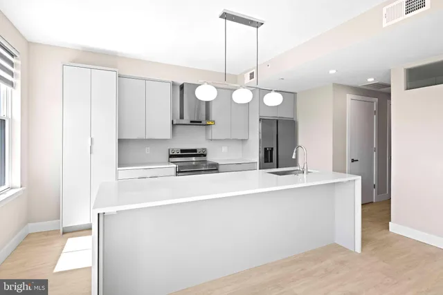 a kitchen with kitchen island granite countertop a sink a stove and a wooden floors