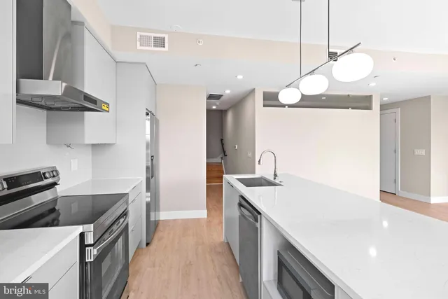 a kitchen with a sink a counter space cabinets and appliances