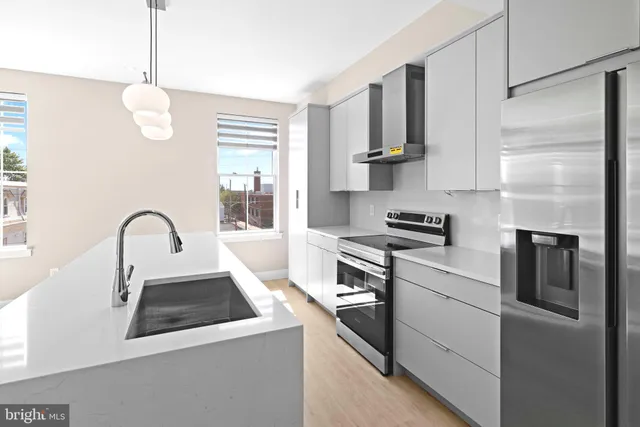 a kitchen with stainless steel appliances a stove microwave and sink