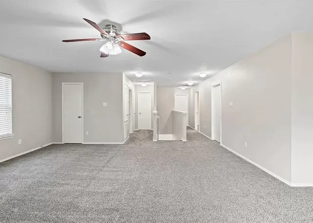 a view of an empty room with a ceiling fan