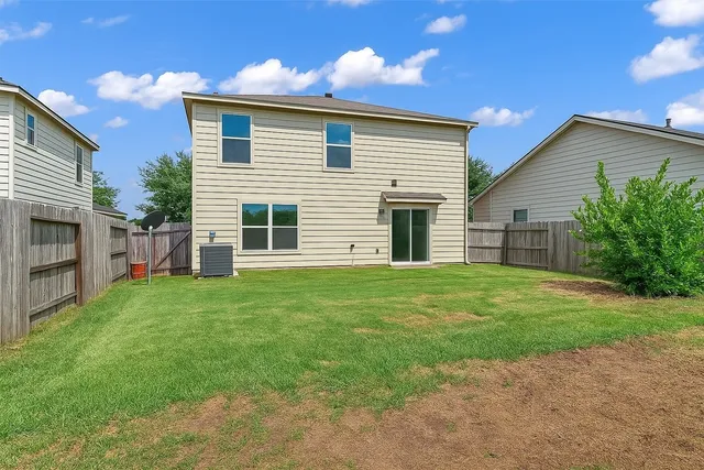 a view of a backyard with plants and large tree
