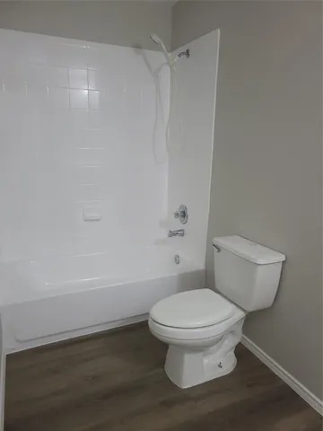 a white toilet sitting next to a bath tub
