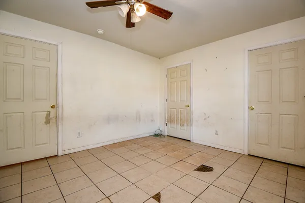 an empty room with chandelier fan