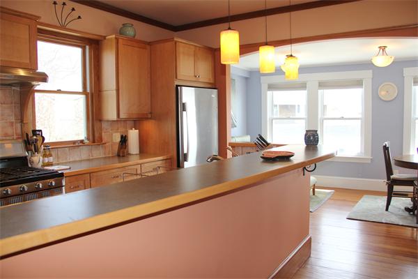 8 Salt Island Road Gloucester, MA 01930 - Photo 4 of 20 a view of a kitchen with kitchen island a large window cabinets a sink and stainless steel appliances