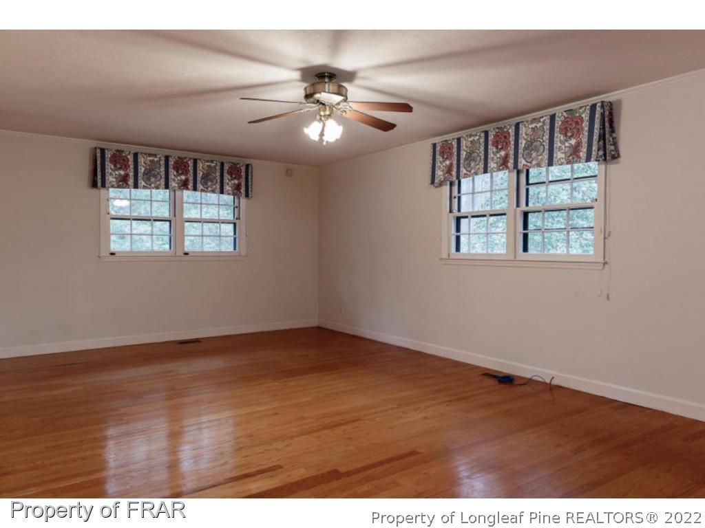 495 Crest Road Southern Pines, NC 28387 - Photo 7 of 21 a view of an empty room with wooden floor and a window