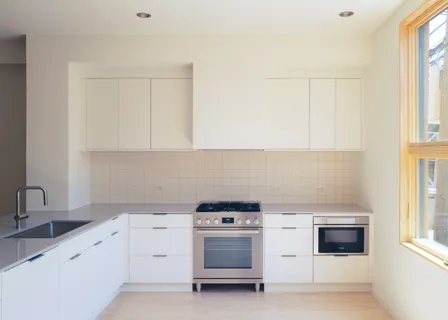 a kitchen with white cabinets and a stove