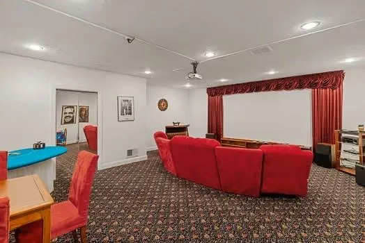 a living room with furniture a flat screen tv and a floor to ceiling window