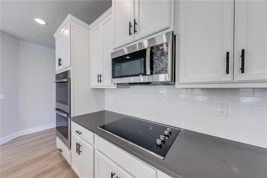 114 Classic Overlook Homer, GA 30547 - Photo 16 of 39 a kitchen with stainless steel appliances white cabinets and wooden floor