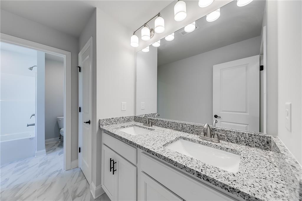 114 Classic Overlook Homer, GA 30547 - Photo 33 of 39 a bathroom with a granite countertop double vanity sink a mirror and shower