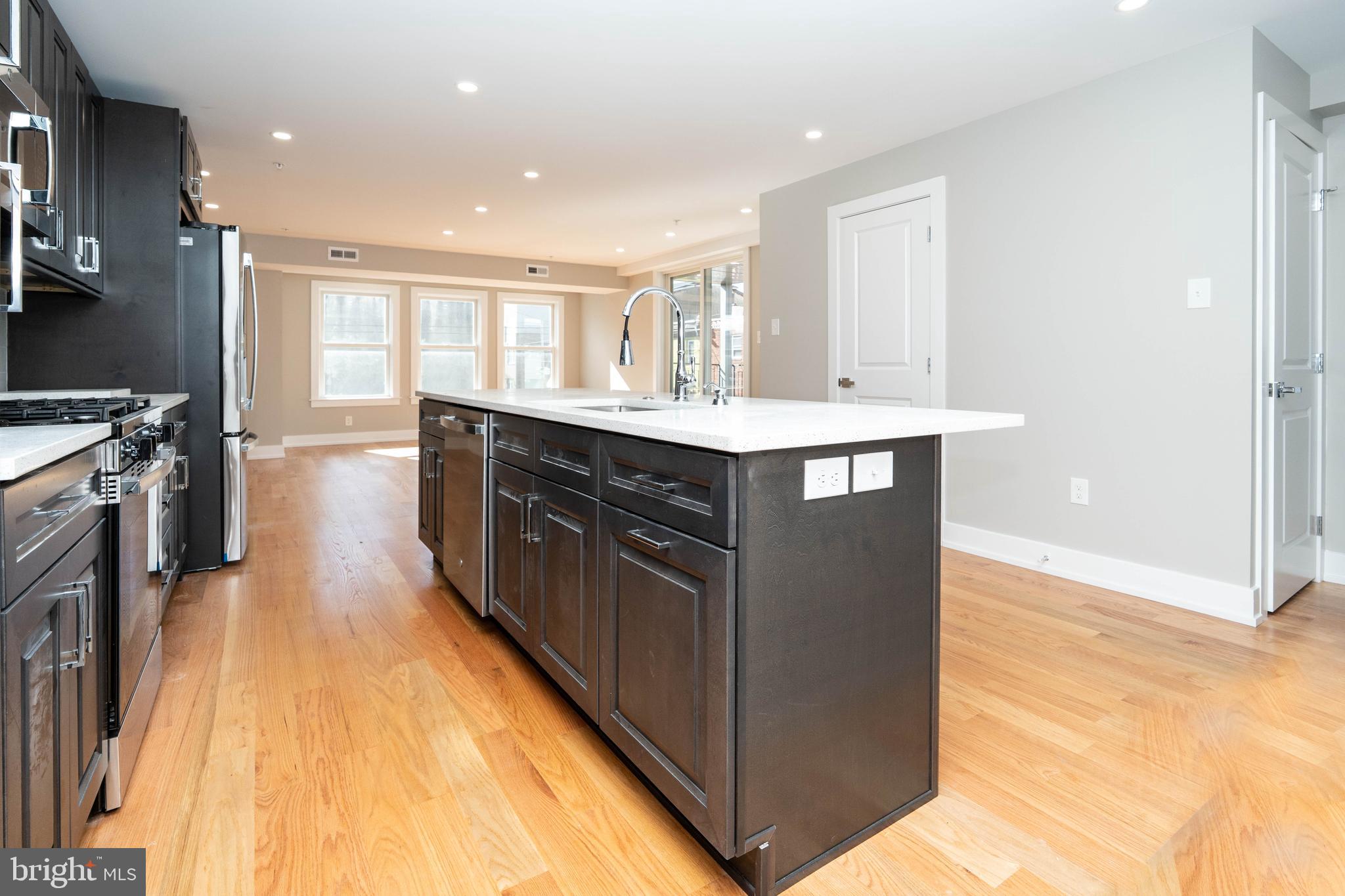 1711 South 5th Street, Unit 3 Philadelphia, PA 19148 - Photo 2 of 9 a kitchen with kitchen island a sink appliances and cabinets