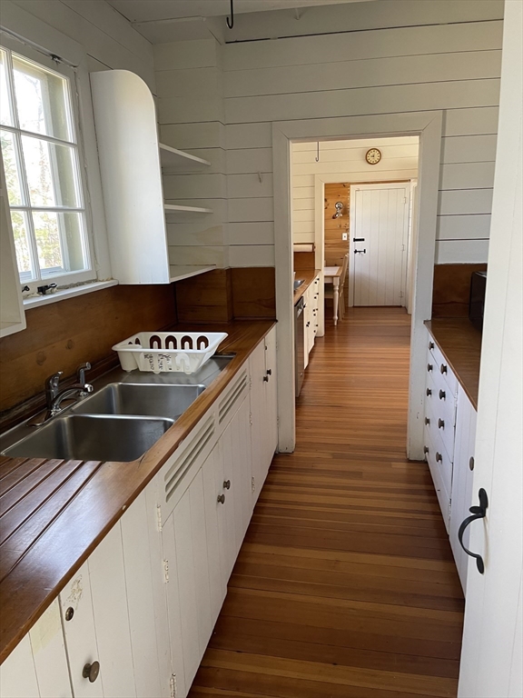 45 Old Cove Road Duxbury, MA 02332 - Photo 5 of 12 a hallway with wooden floor windows and a kitchen