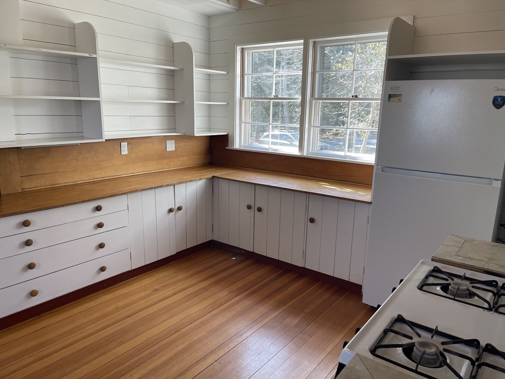 45 Old Cove Road Duxbury, MA 02332 - Photo 6 of 12 a kitchen with granite countertop a stove and a wooden floor