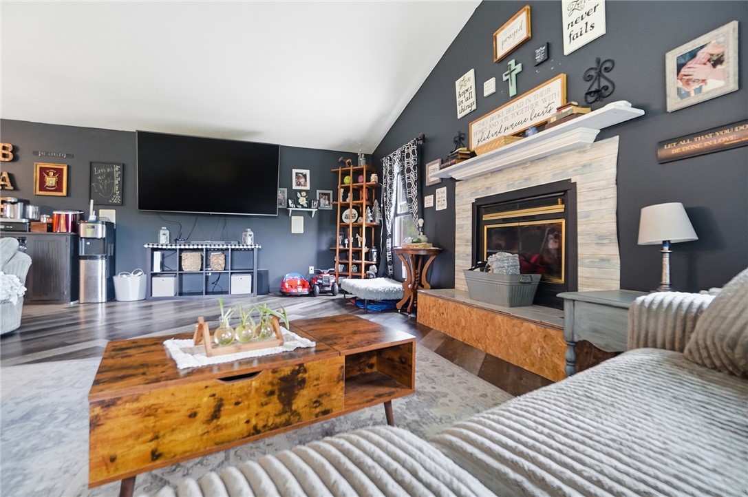 5209 North Addison New Carlisle Road St. Paris, OH 43072 - Photo 21 of 47 This inviting living space features vaulted ceilings and a cozy fireplace, perfect for relaxation.