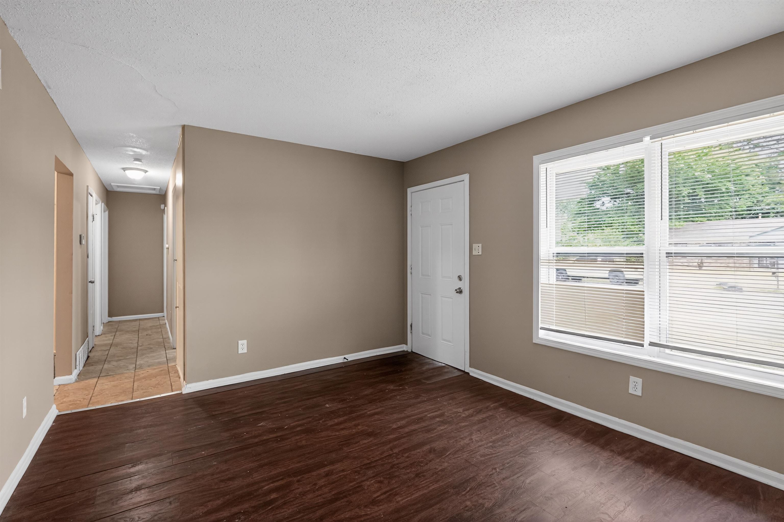 3608 Cane Ridge Drive Memphis, TN 38109 - Photo 12 of 31 Spacious room with dark wood-finish flooring, neutral-toned walls, and white trim