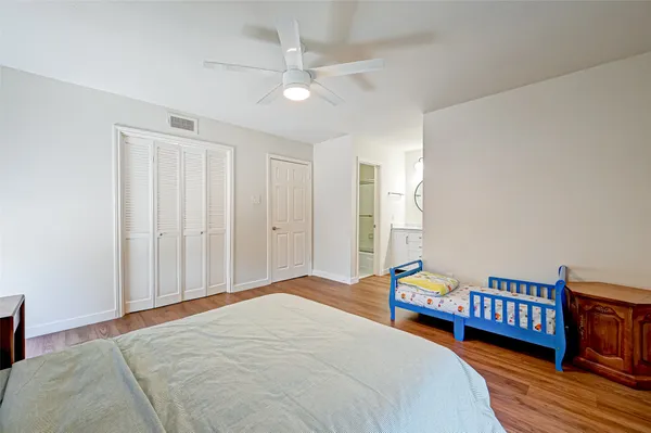 a bedroom with bed and wooden floor
