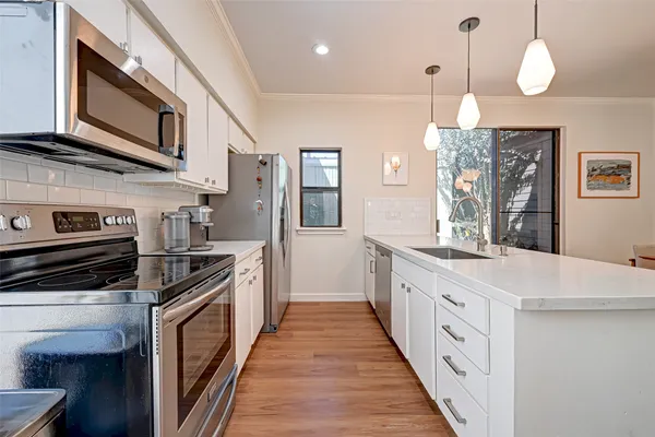 a large kitchen with stainless steel appliances granite countertop a stove and a sink