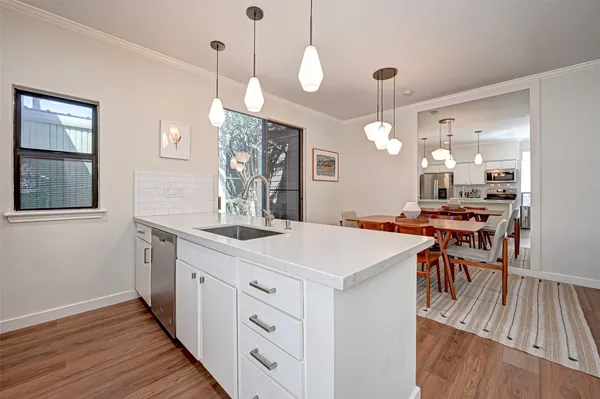 a large kitchen with kitchen island a stove a sink a dining table and chairs