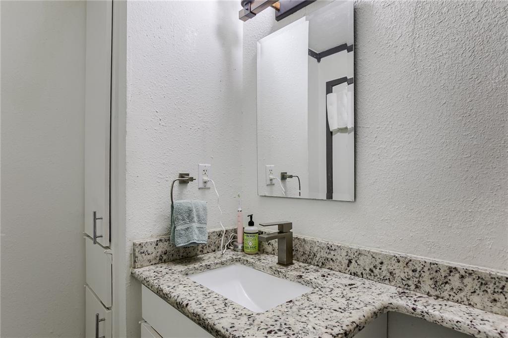 620 South 1st Street, Unit 107 Austin, TX 78704 - Photo 12 of 22 a bathroom with a granite countertop sink and a mirror